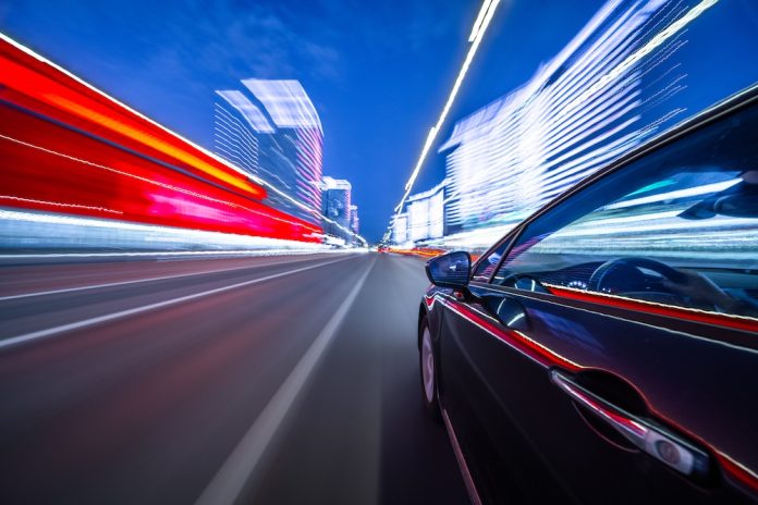 View,From,Side,Of,Car,Moving,In,A,Night,City,